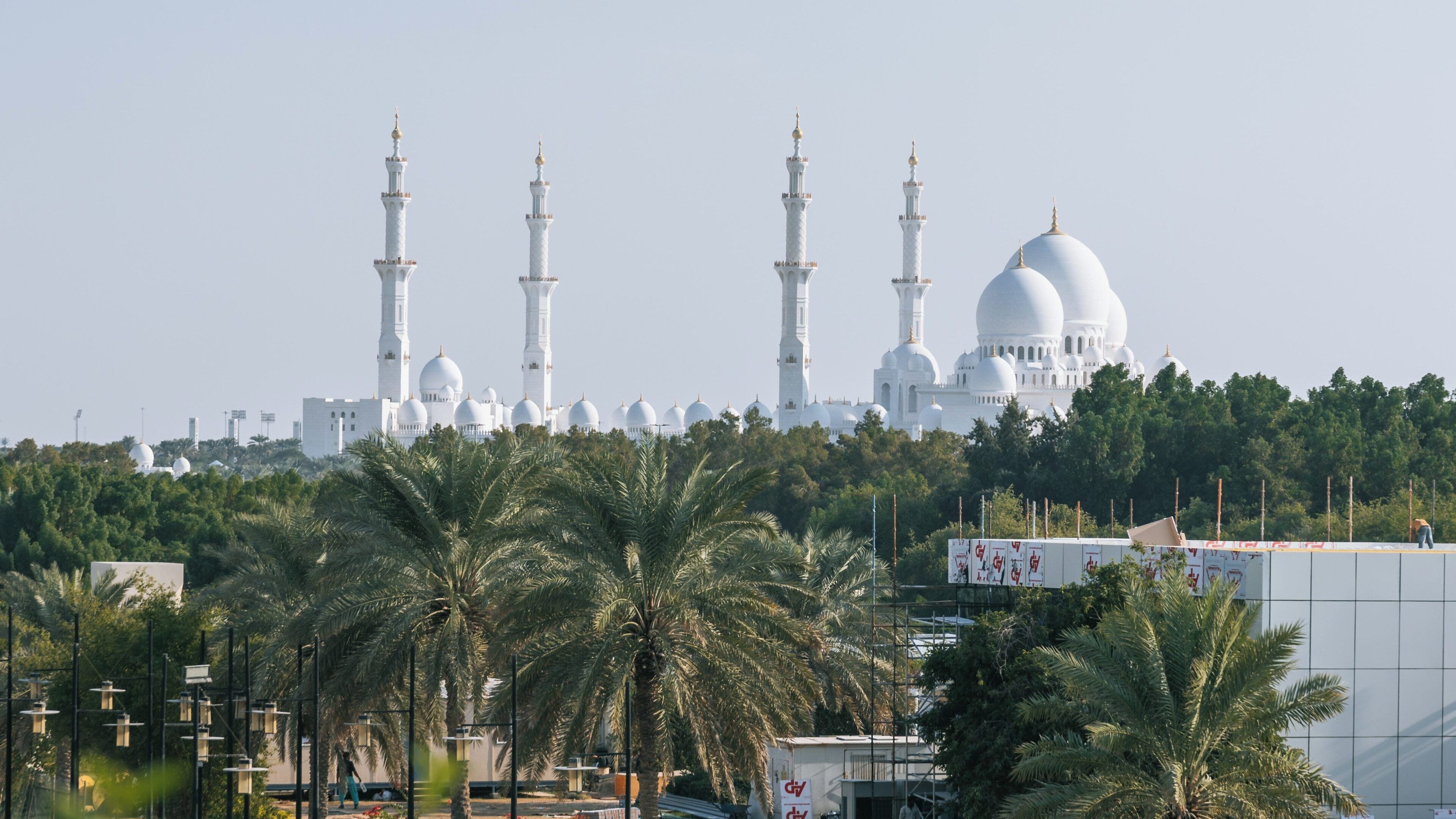 Stunning view of Khalifa Park showcasing the majestic Sheikh Zayed Grand Mosque in Abu Dhabi with lush palm trees surrounding the area