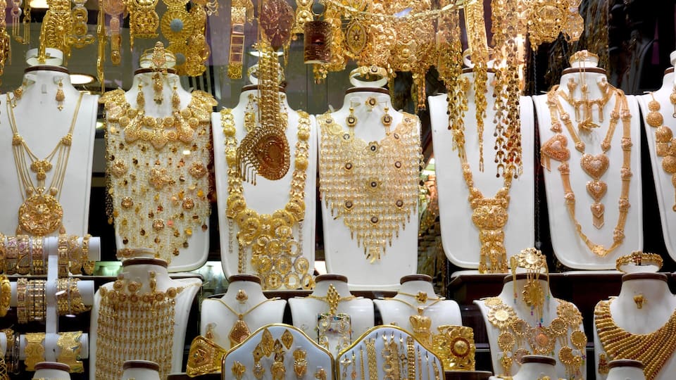 A display of various gold jewelry pieces on white mannequins.