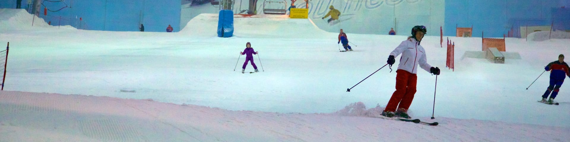 An indoor ski slope with artificial snow, ski lifts, and a large advertisement for 'need'.