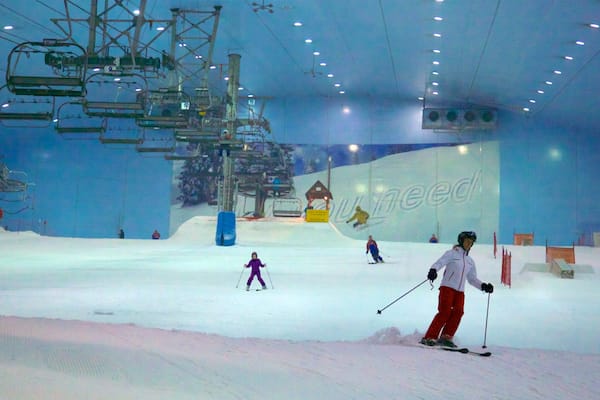 Eine Indoor-Skihallett mit Kunstschnee, Skiliften und einer großen Werbung für 'need'.