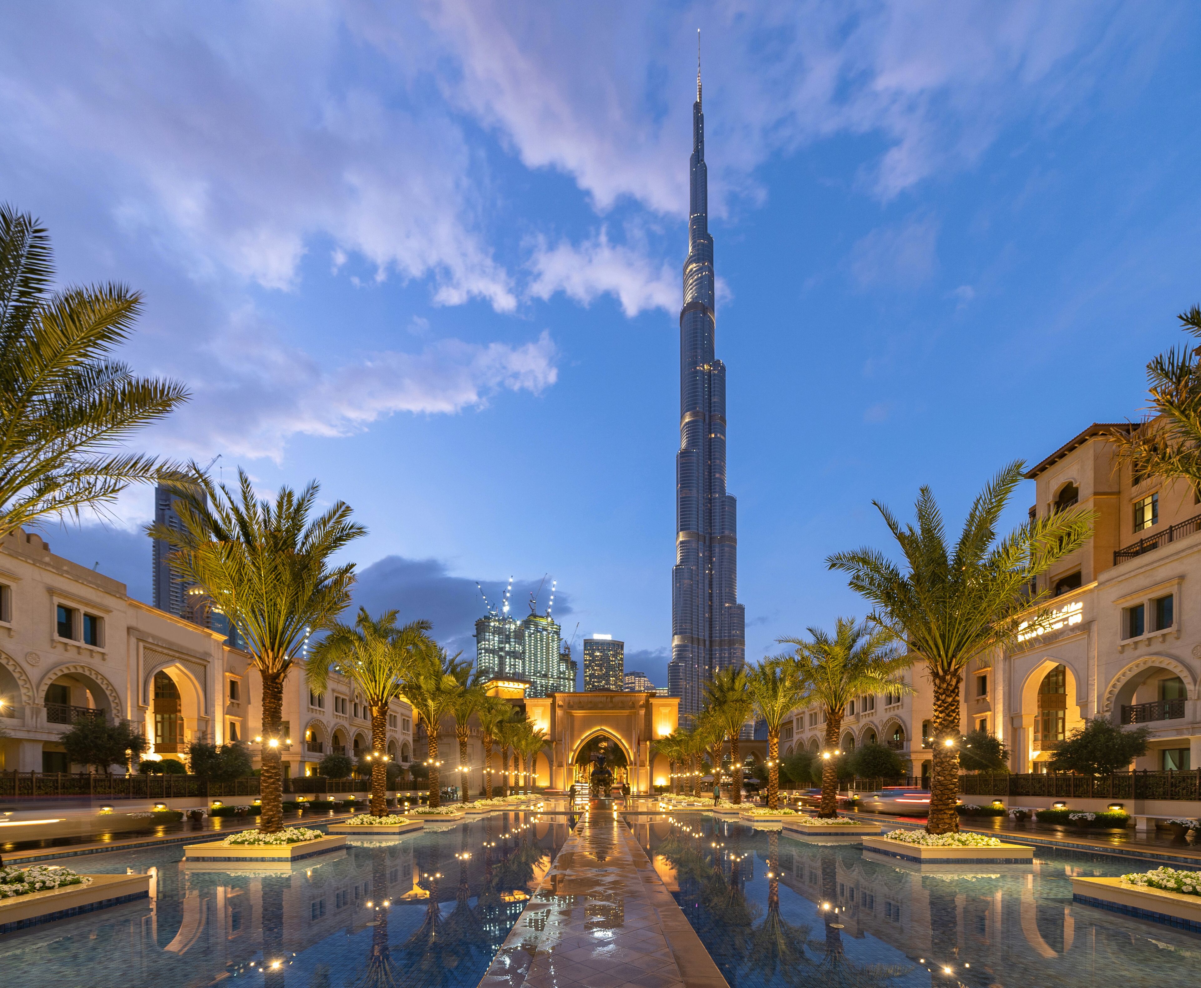Burj Khalifa and palm trees in Palace Downtown, Dubai skyline, United Arab Emirates or UAE. Financial district and business area in smart urban city. Skyscraper and high-rise buildings.