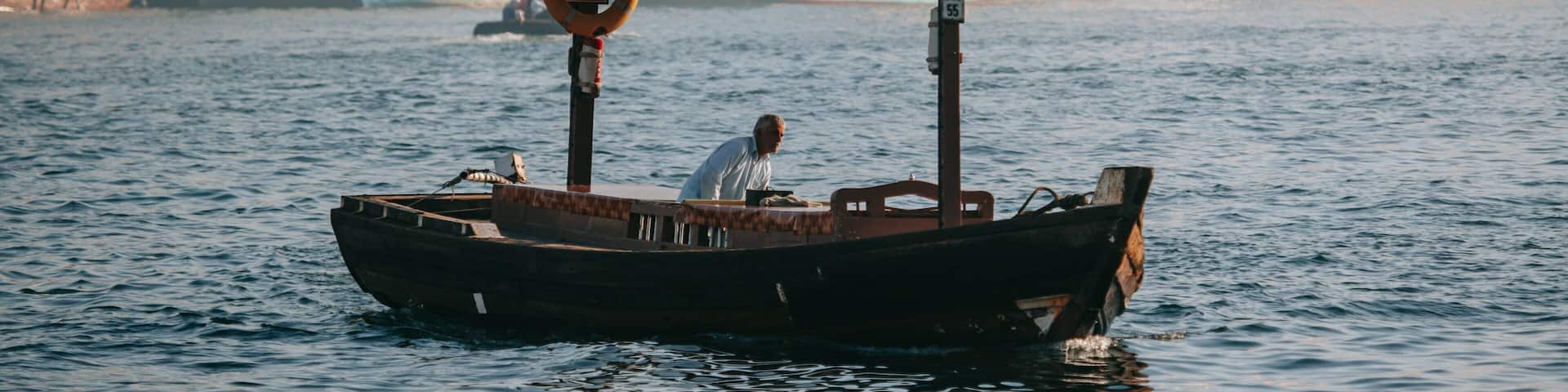 Dubai Creek which includes boating and a bay or harbor as well as an individual male