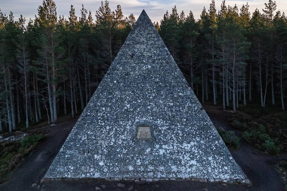 Una gran pirámide de piedra rodeada de bosque.