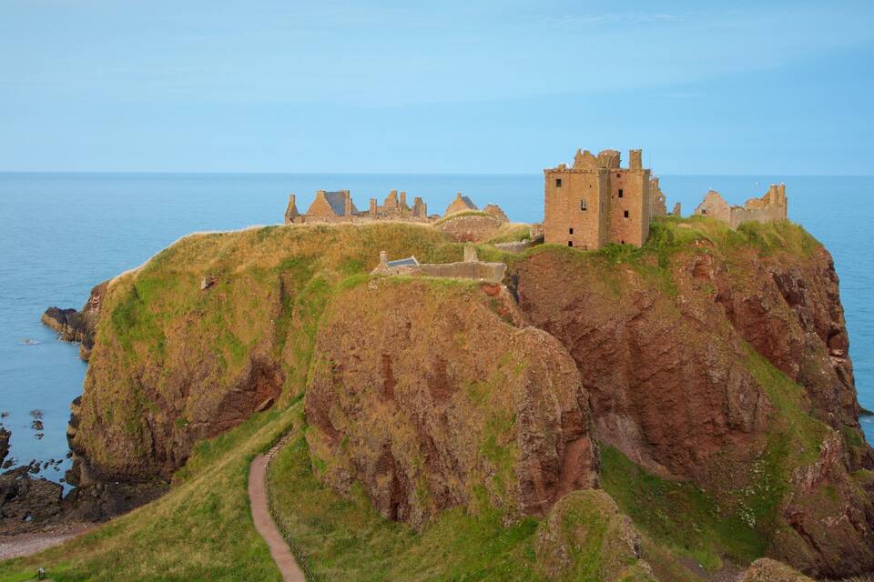 A coastal castle on a cliff overlooking the sea.