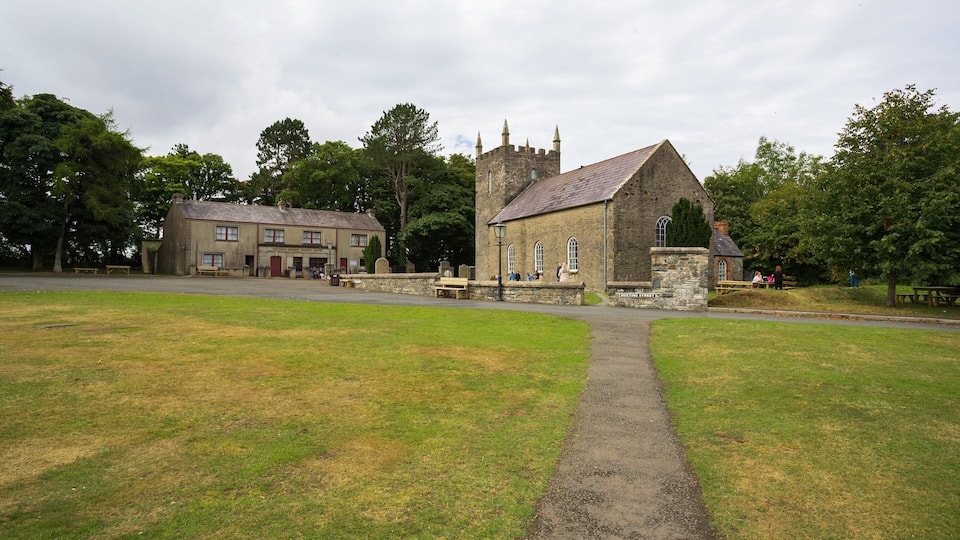 A stone church with a pointed roof and a stone archway.