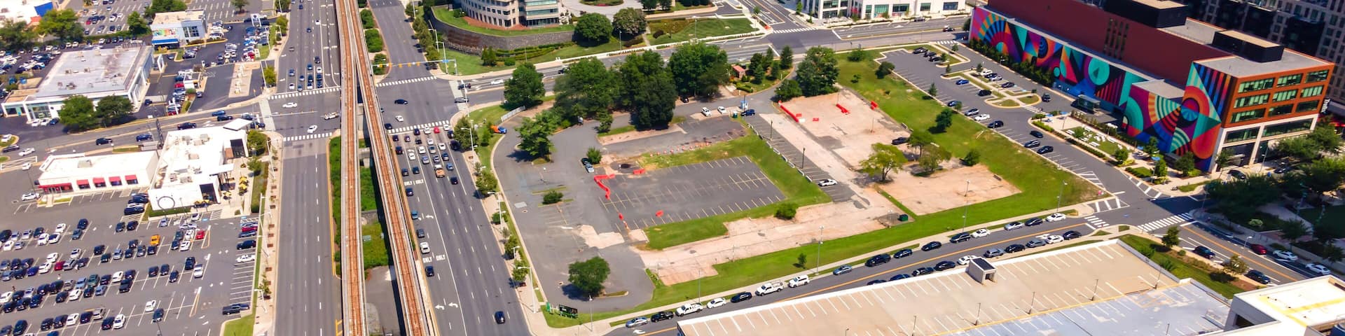 Aerial view of Tysons Virginia with metro line and modern buildings under summer sky
