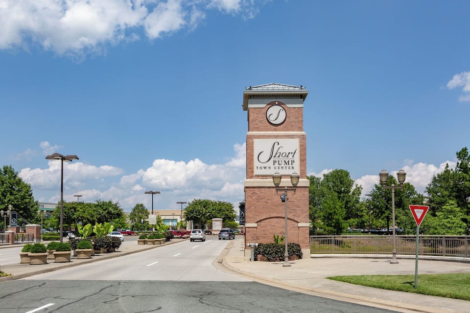 A street view with a prominent clock tower labeled "Short Pump Town Center" and a yield sign.