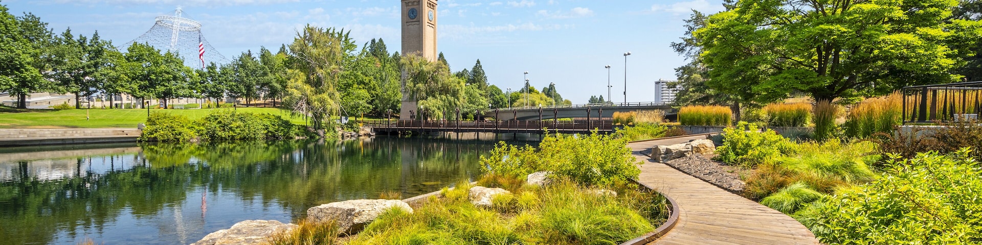 Summer day along the Spokane River in Riverfront Park with the Clock Tower, Pavilion and walking path in view.