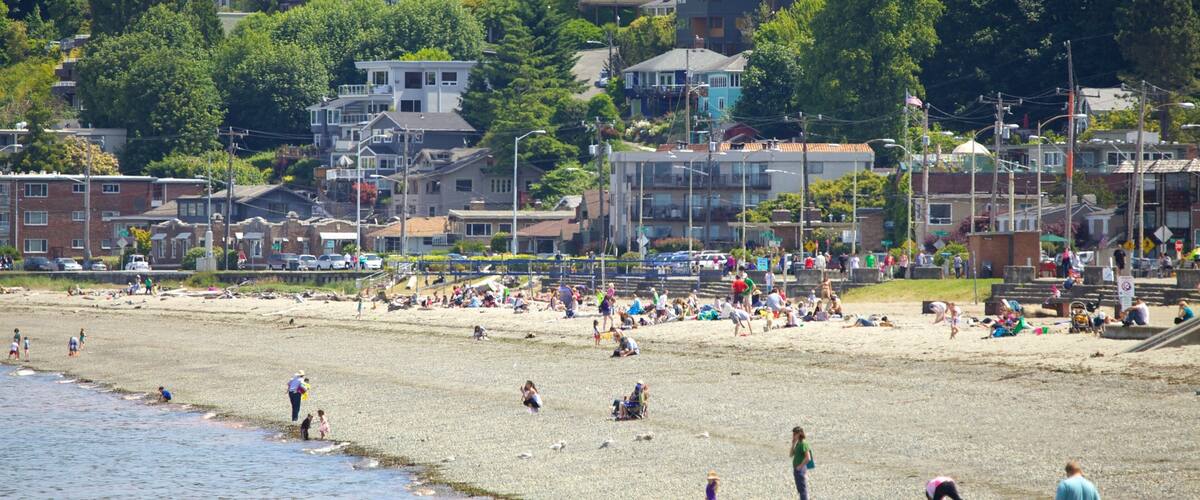 Vibrant summer day at Alki Beach in Seattle with families enjoying sun and sand by the waterfront