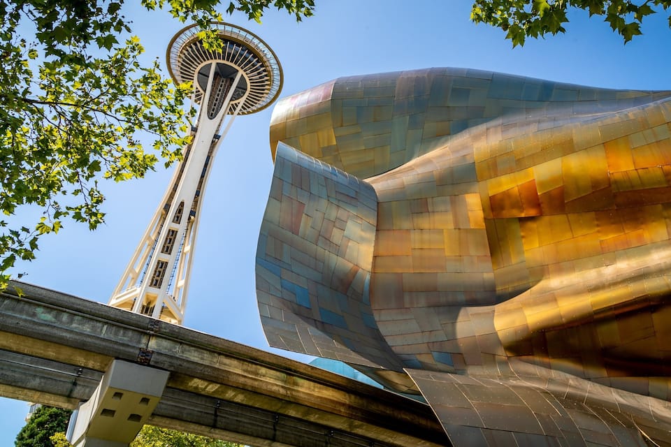 A futuristic building with a curved, metallic facade and a tall, circular tower with a spiral design.