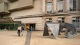 A large metal sculpture in front of a building with a sign for the Ulster Museum.