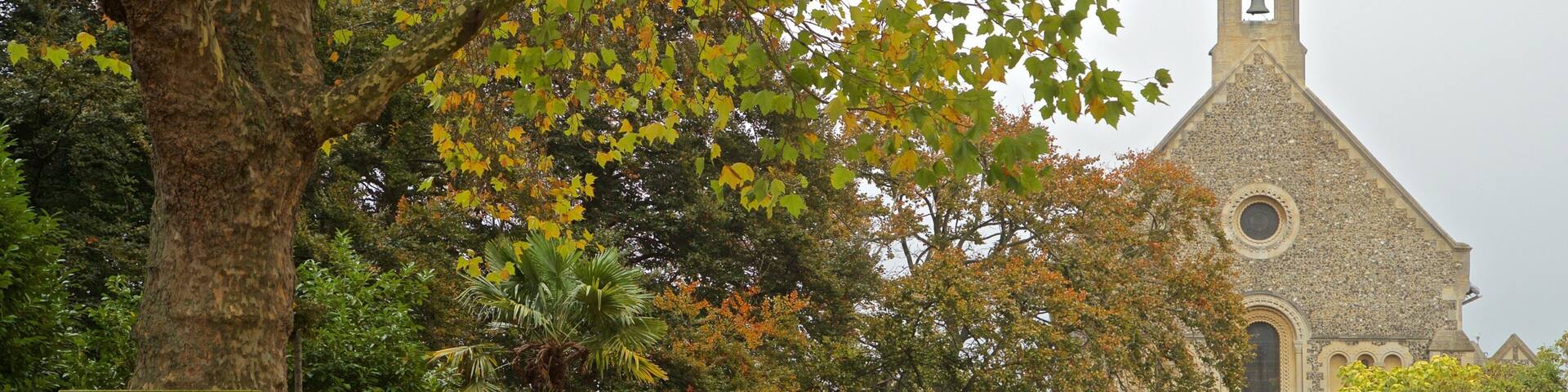 Forbury Gardens showing a church or cathedral, a garden and fall colors