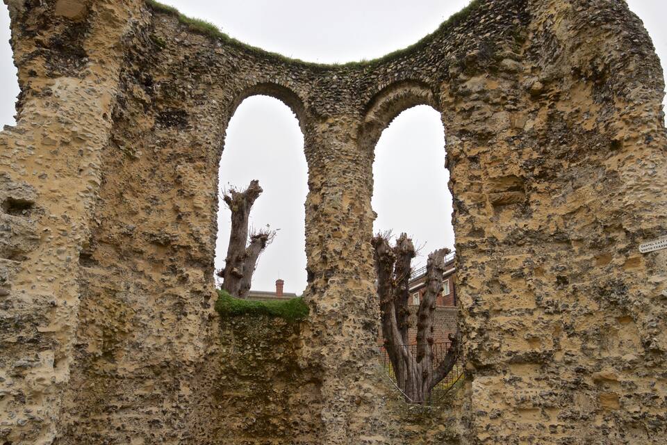 The ruins of a stone archway with moss growth and a sign reading "Chapel Last of South Transp."