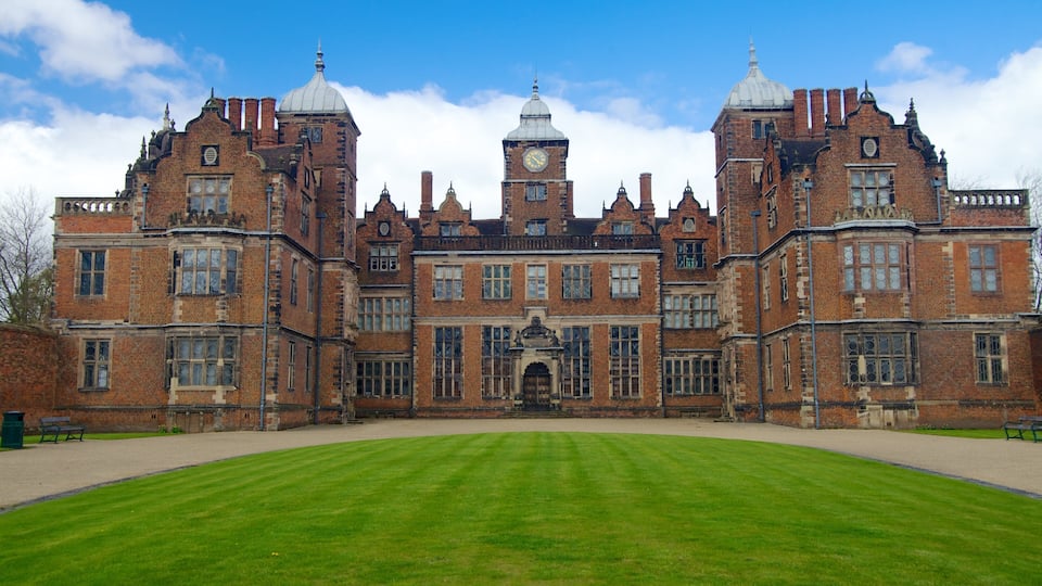 A large, historic building with two prominent towers and a central clock tower.