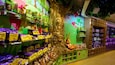 A candy store with shelves of caramel and chocolate bars, a large tree sculpture, and a rabbit statue.