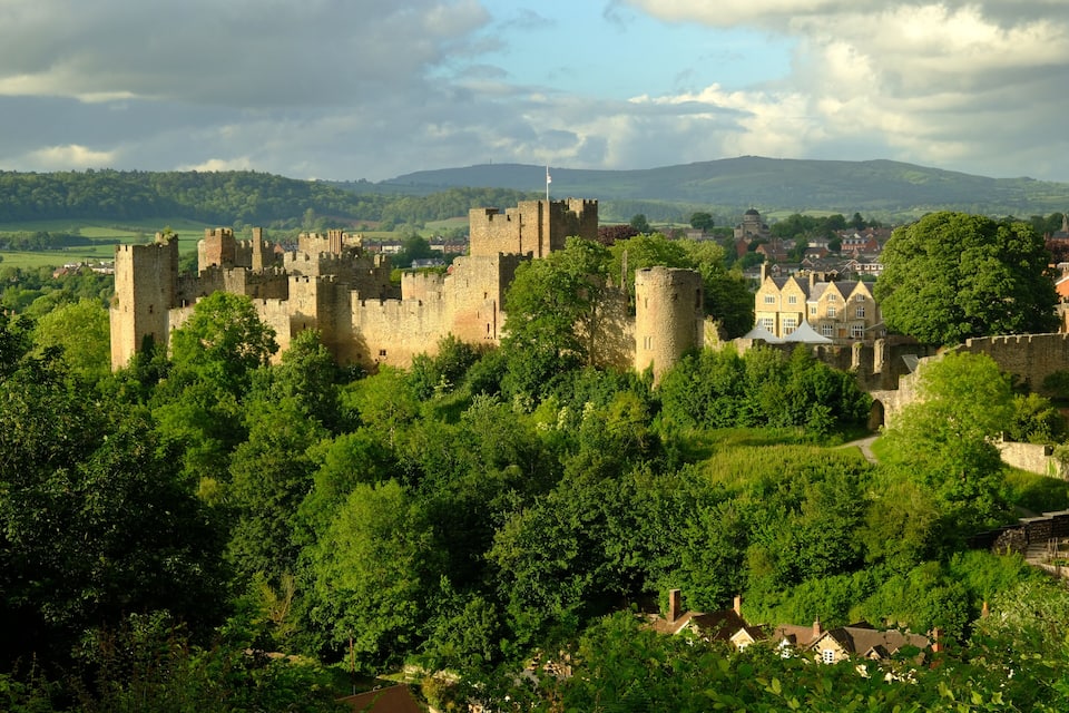 Un château historique, entouré d’une végétation luxuriante, et une petite ville.