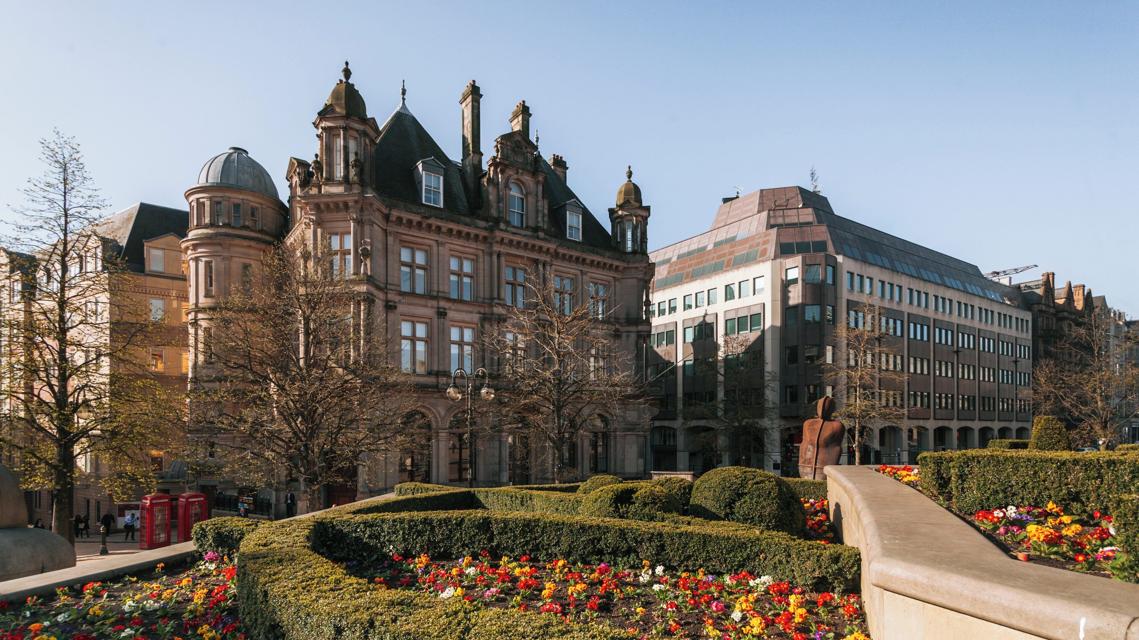 Victoria Square in Birmingham City Centre showcases beautiful architecture and vibrant floral displays under clear skies