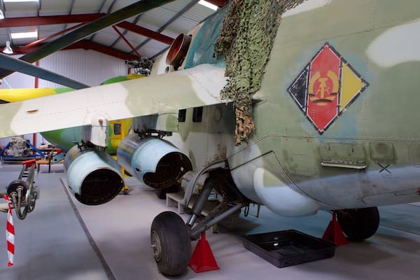 Un avion militaire peint avec un motif de camouflage, doté d’hélices bien visibles et dont le fuselage est endommagé.