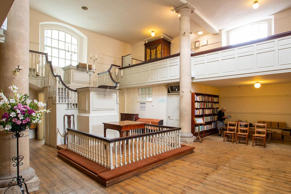 Una biblioteca àmplia amb terres de fusta, una escala i una gran biblioteca.