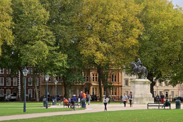 Queen Square showing a park and a statue or sculpture as well as a small group of people