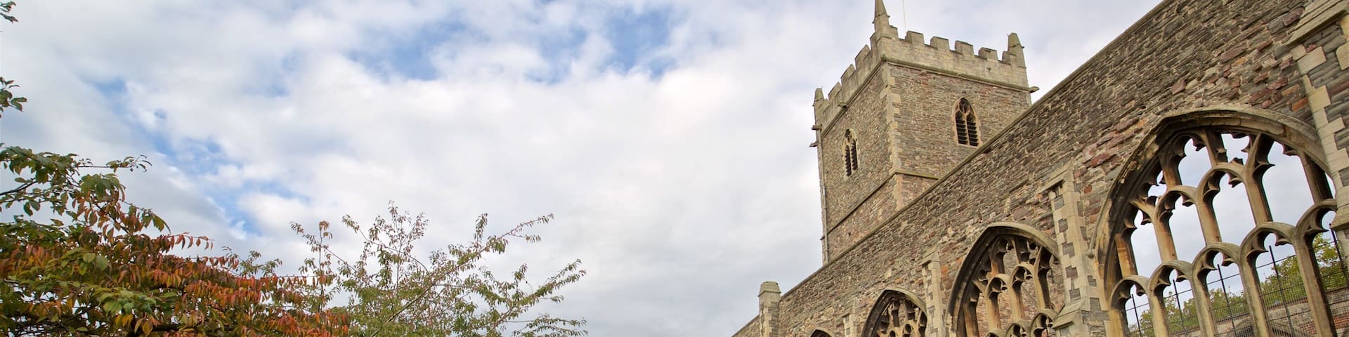 A historic stone building with arched windows and a tower.