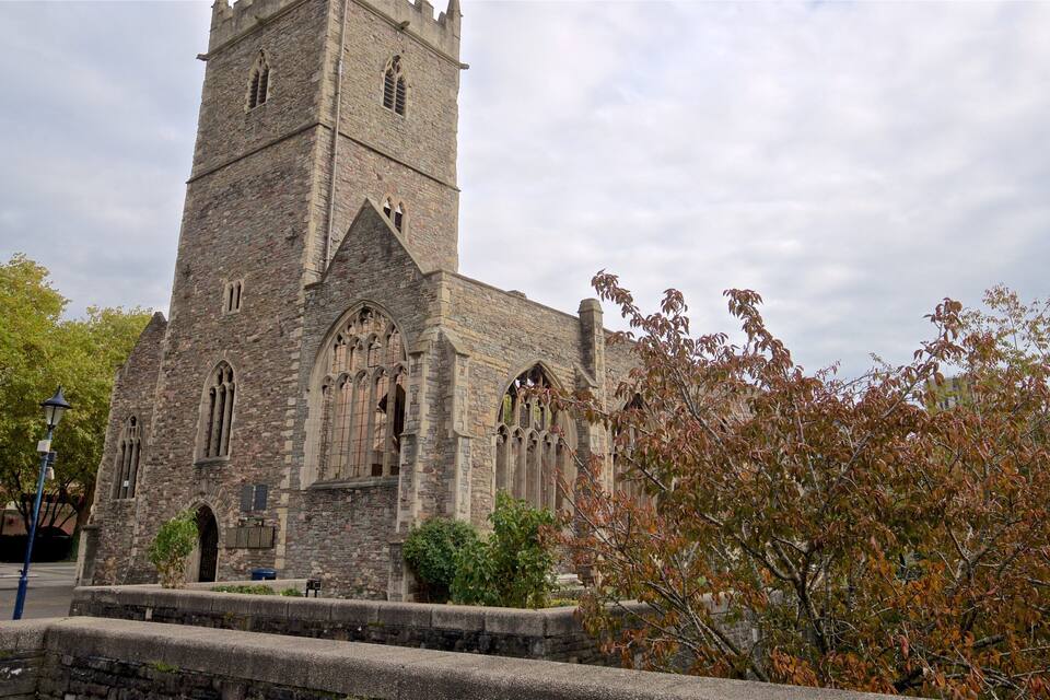 A historic stone church with a tall tower and arched windows.