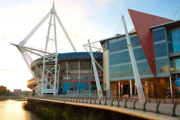 A modern stadium with a distinctive sail-like structure and a glass facade.