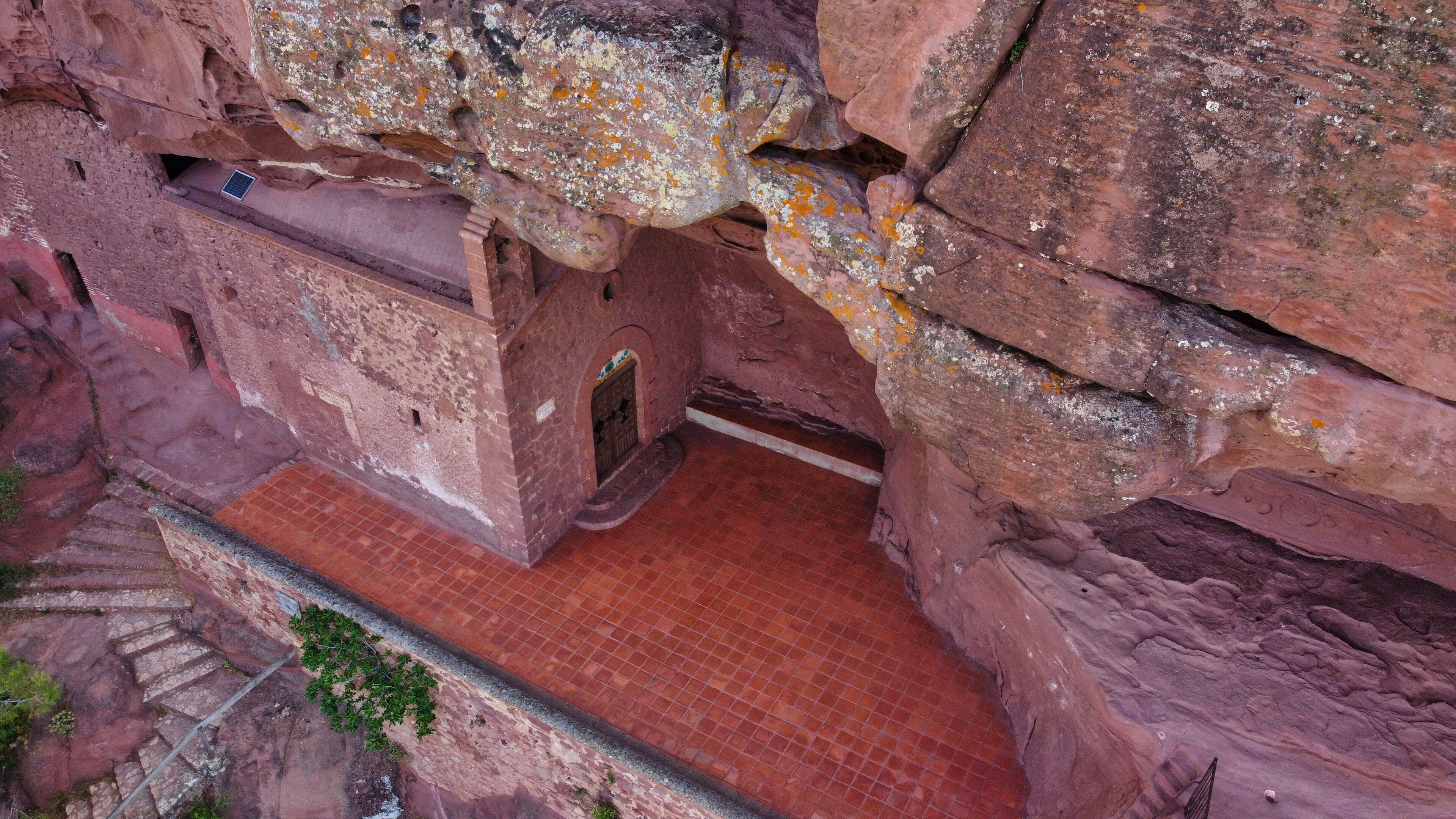 A cave entrance with a brick staircase leading down.