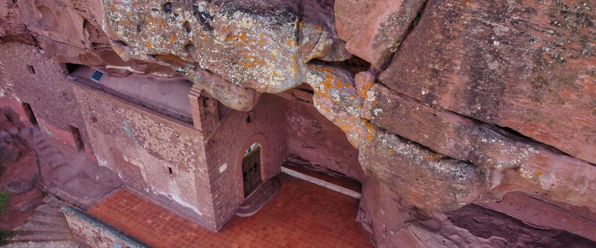 A cave entrance with a brick staircase leading down.