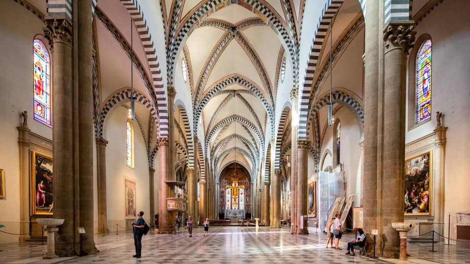 A cathedral interior with high vaulted ceilings, stained glass windows, and classical columns.