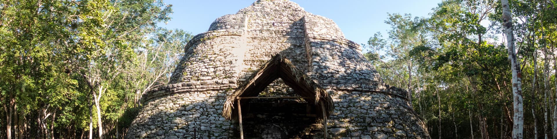 Young tourist doing yoga at a Mayan pyramid in Coba.