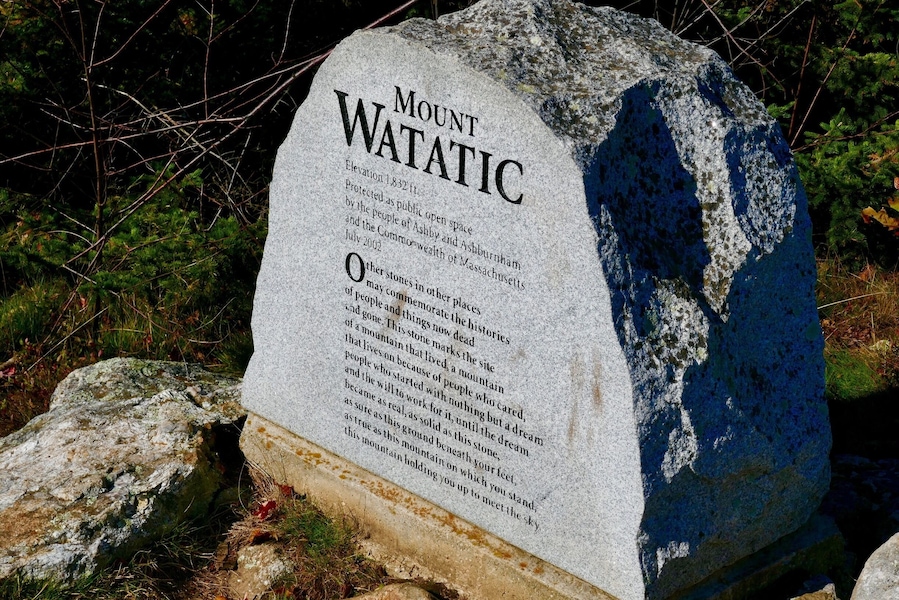 Ein aus Granit gefertigtes Denkmal mit der Inschrift 'Mount WATATIC' und Angaben zu seiner Höhe und historischen Bedeutung.