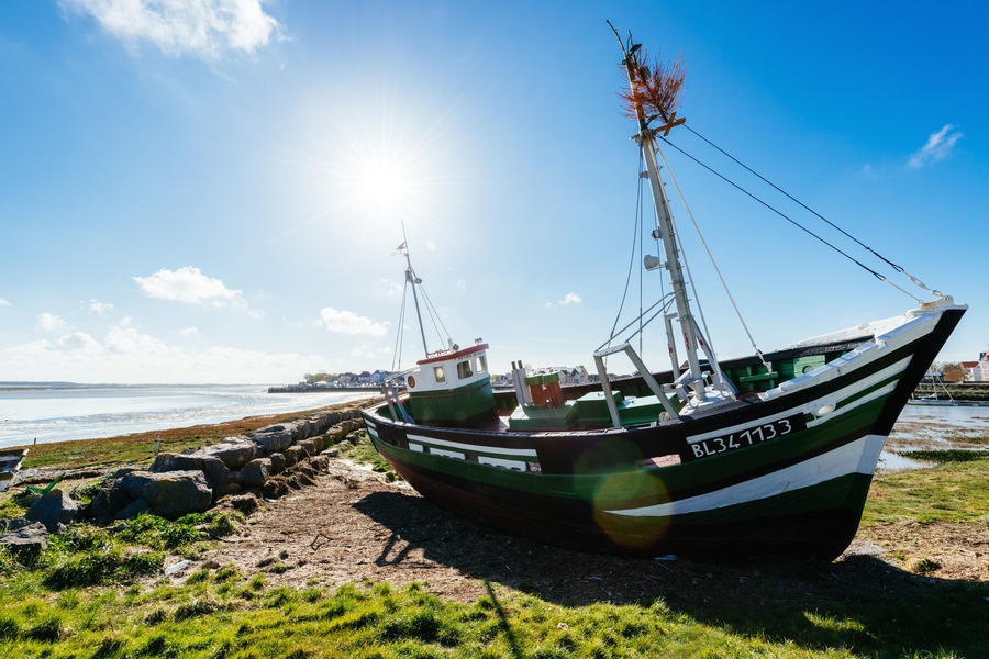 A grounded ship in the port of Le Crotoy, in the Bay of the Somme, in backlight with blue sky. ; Shutterstock ID 590555828; purchase_order: SP-1332 HA Batch 2 August 2018; Order: ; client: HomeAway; o