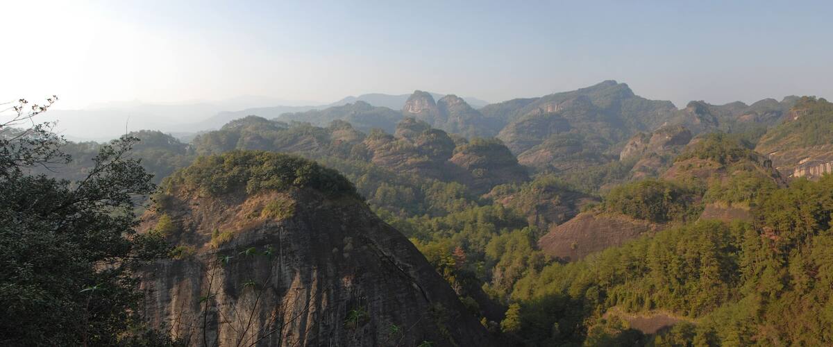 A mountainous landscape with dense forests and rocky cliffs.
