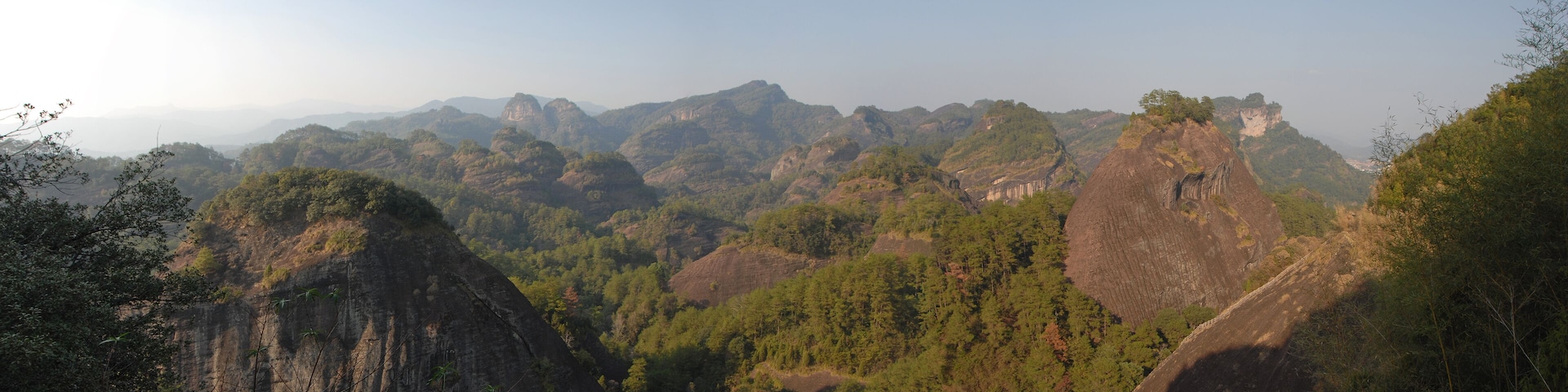 A mountainous landscape with dense forests and rocky cliffs.