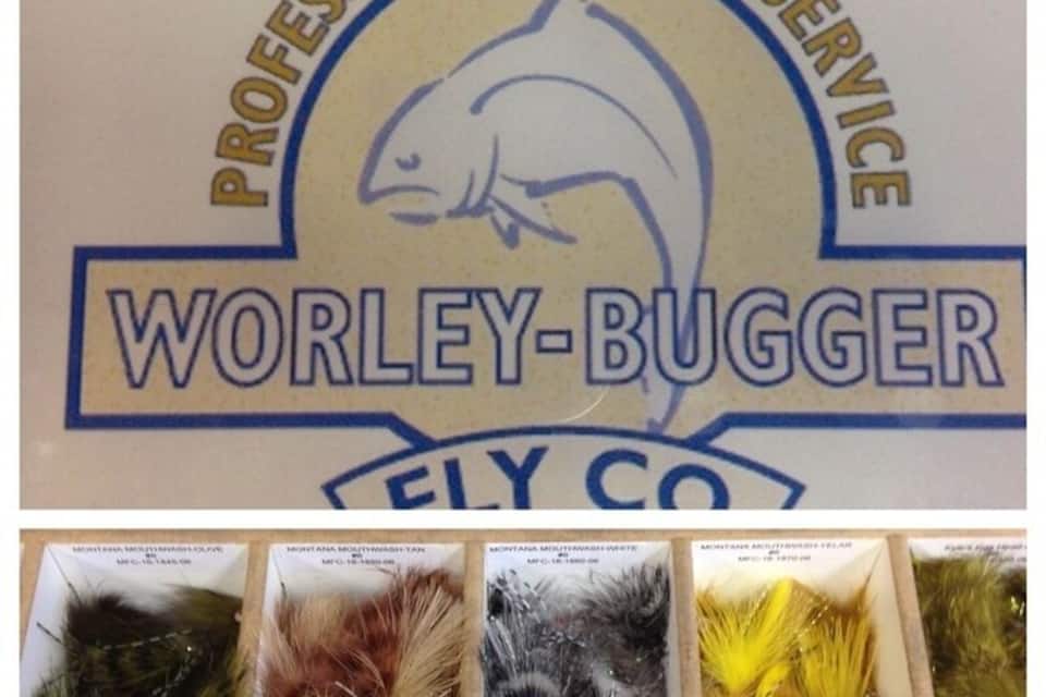 Logotipo para Professional Guide Service con un pez y el nombre Worley-Bugger Fly Co. Abajo, hay cajas con plumas de diferentes colores.