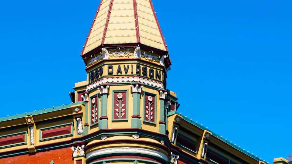 A corner building with a distinctive red and yellow facade, a pointed roof, and the name 'DAVIDSON' visible on the structure.