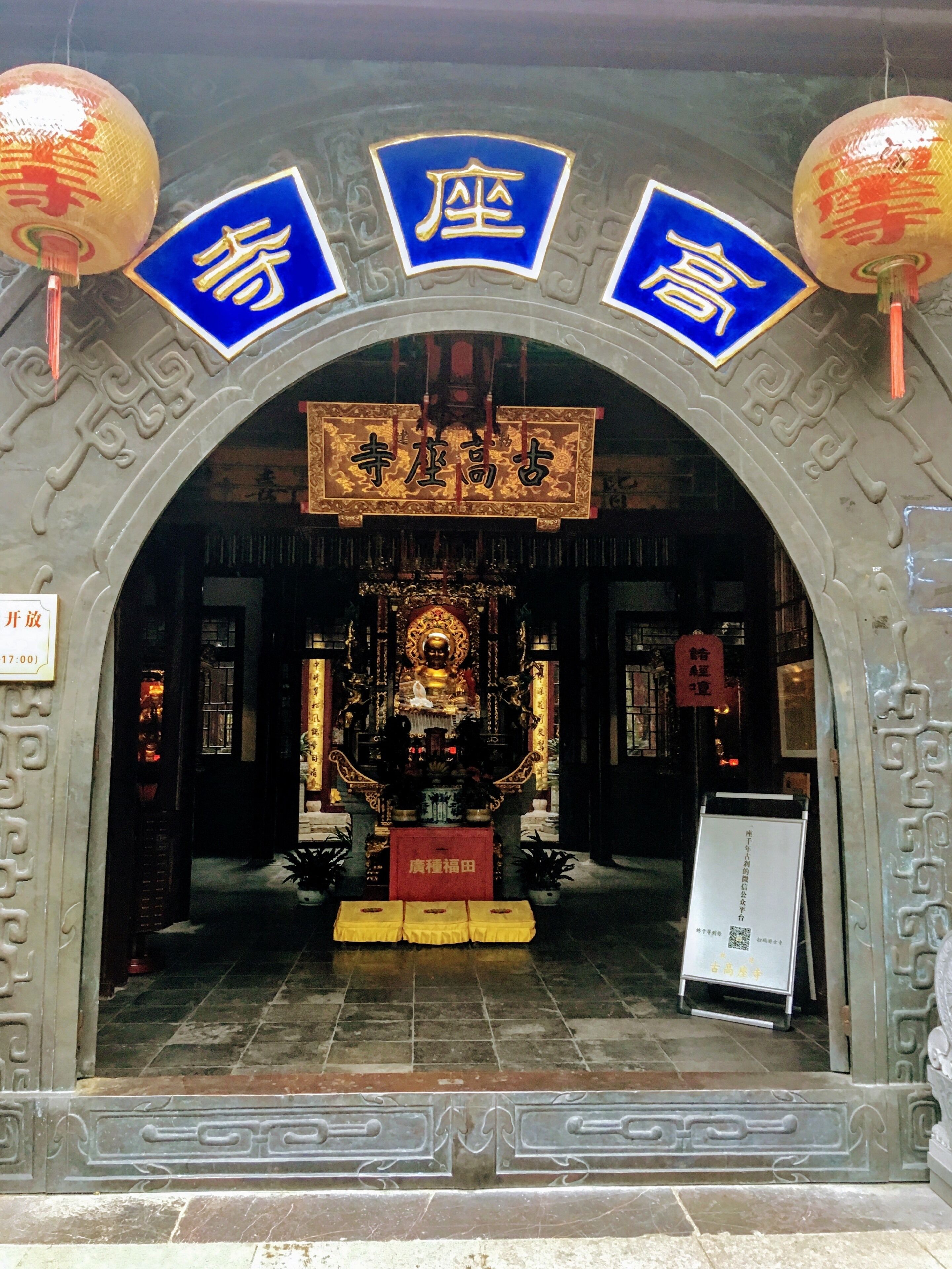 An ornate entrance with traditional Chinese architecture, including a golden statue and intricate carvings.