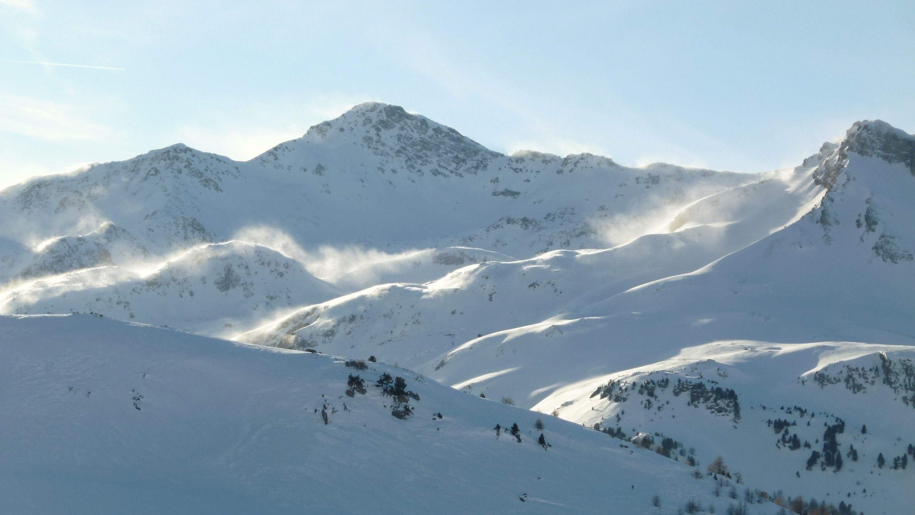 Sommet de montagne enneigé dans les Alpes, avec du blizzard dans la poudreuse (France)