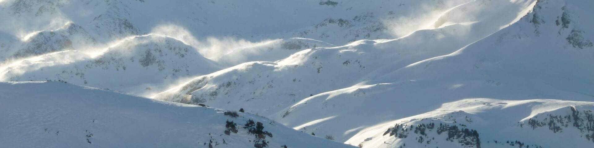 Sommet de montagne enneigé dans les Alpes, avec du blizzard dans la poudreuse (France)