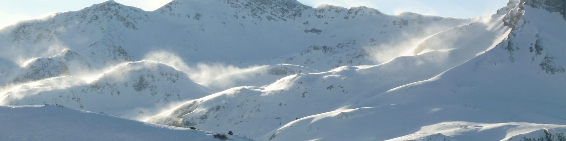 Sommet de montagne enneigé dans les Alpes, avec du blizzard dans la poudreuse (France)
