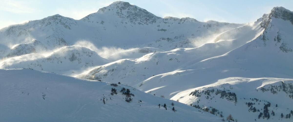 A snow-covered mountain range with rugged peaks and valleys.