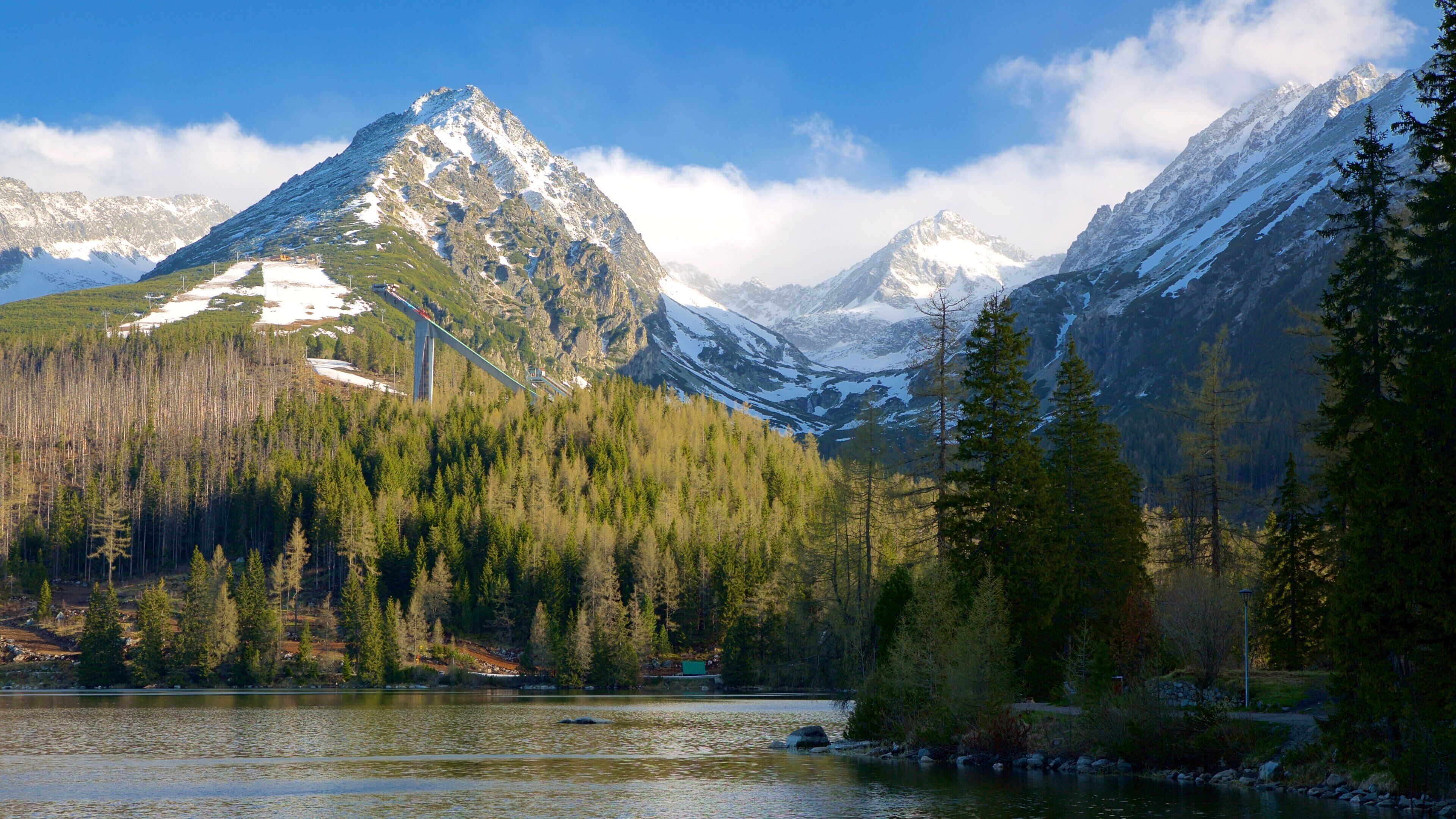 A mountain range with a lake and forested area.