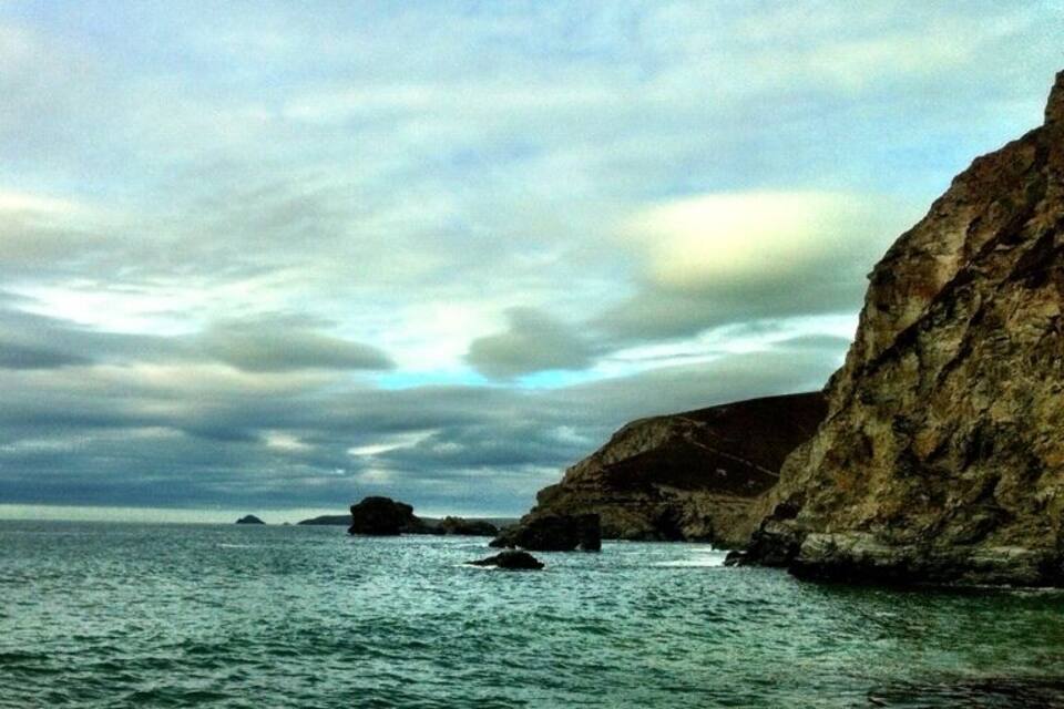 Paisaje costero con acantilados rocosos y mar tranquilo.
