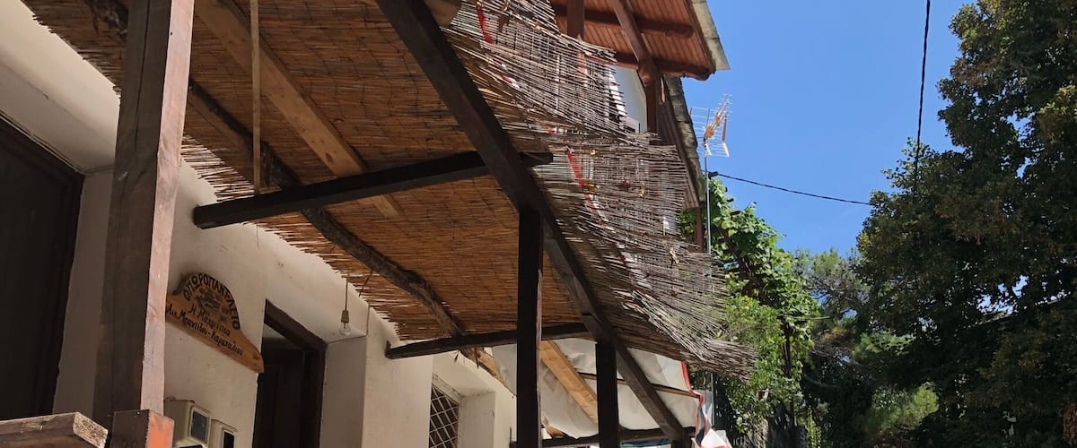 A cobblestone street, wooden balcony railings, and a building with a thatched roof.
