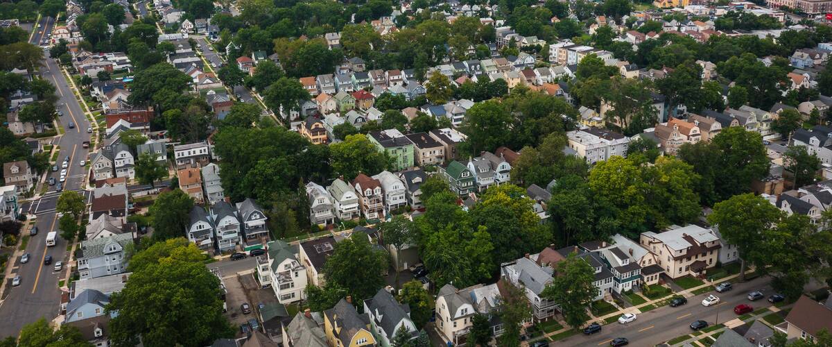 An aerial view of a densely populated urban area with residential houses, streets, and various buildings.