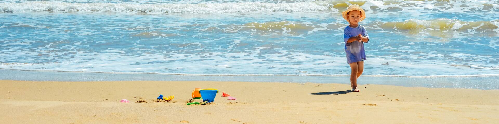 A Chinese kid playing on beach at Putuo Mountain in Ningbo, Zhejiang, China, during summer season