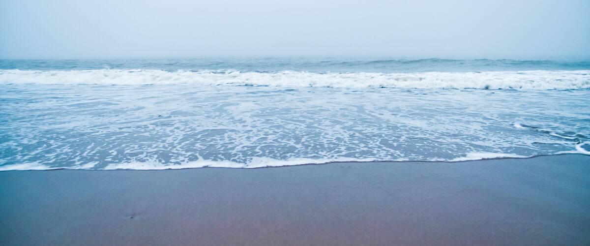 A beach with waves approaching the shore.