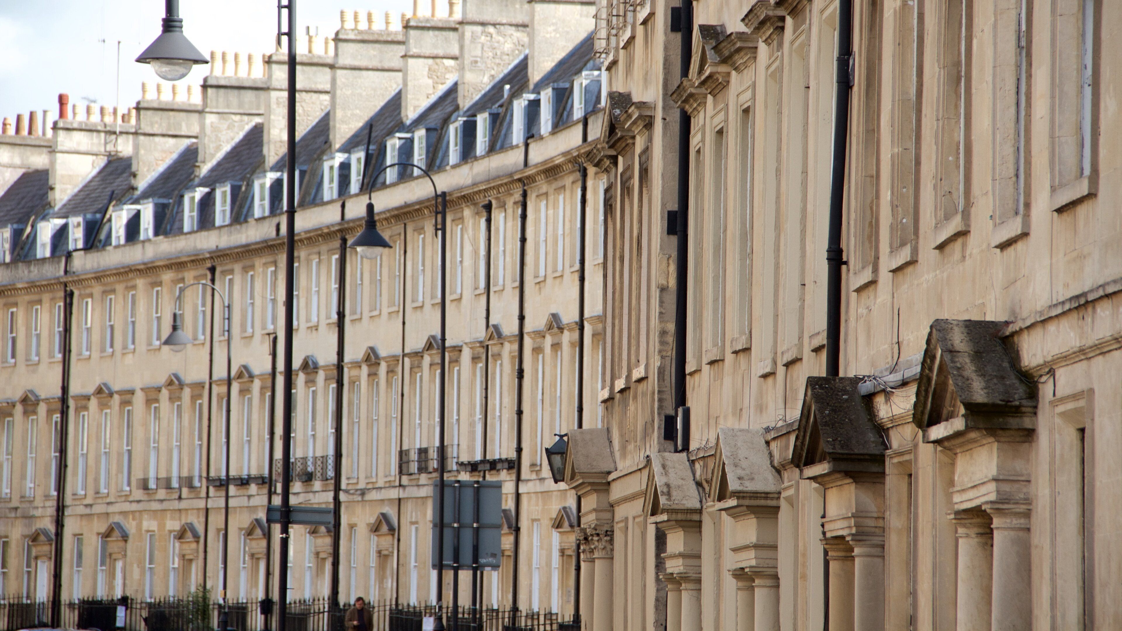A row of historic buildings with uniform facades and steeply pitched roofs.