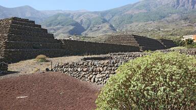 Ancient stone ruins with terraced structures in a mountainous landscape.